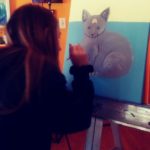 person painting a cat
